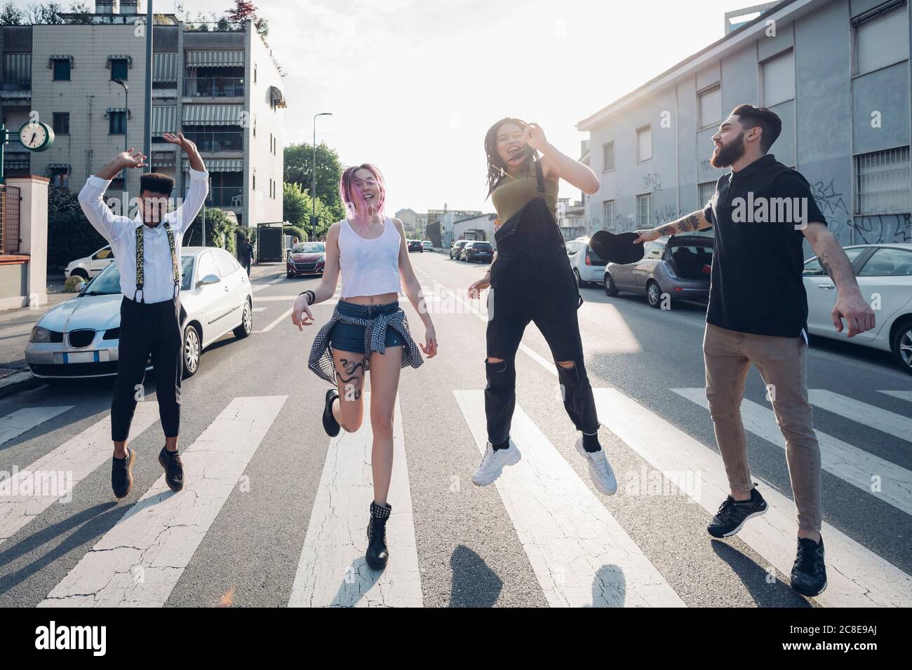 Gruppe von unbeschwerten Freunden springen auf einer Straße in der Stadt Stockfoto