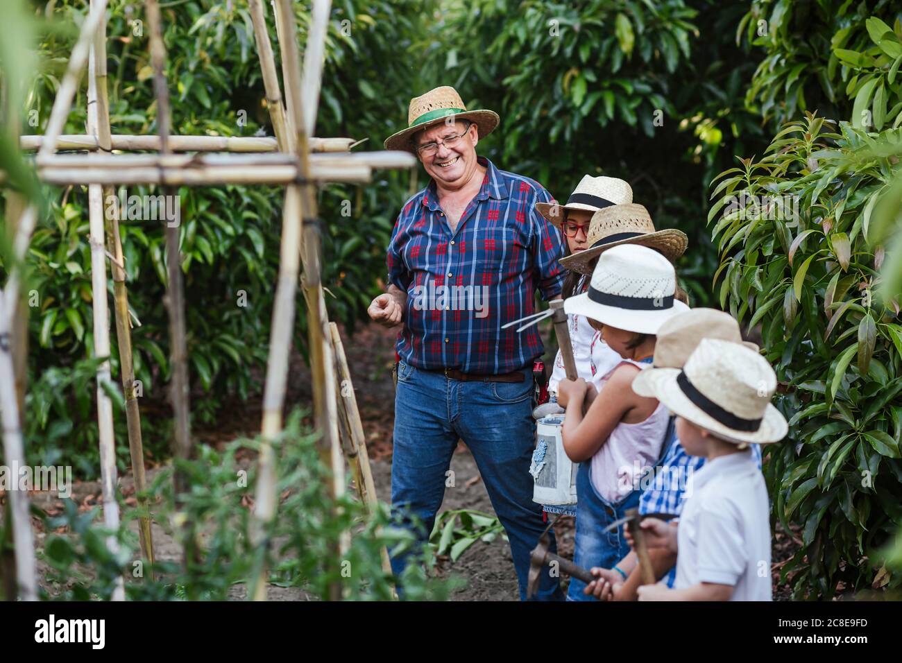 Grandfahter mit Gruppe von Kindern im Garten Stockfoto