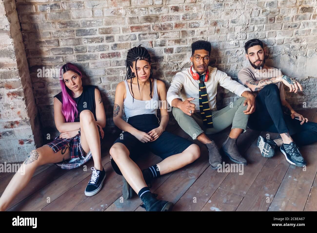 Porträt einer Gruppe von Freunden sitzen auf dem Boden in Ein Loft Stockfoto