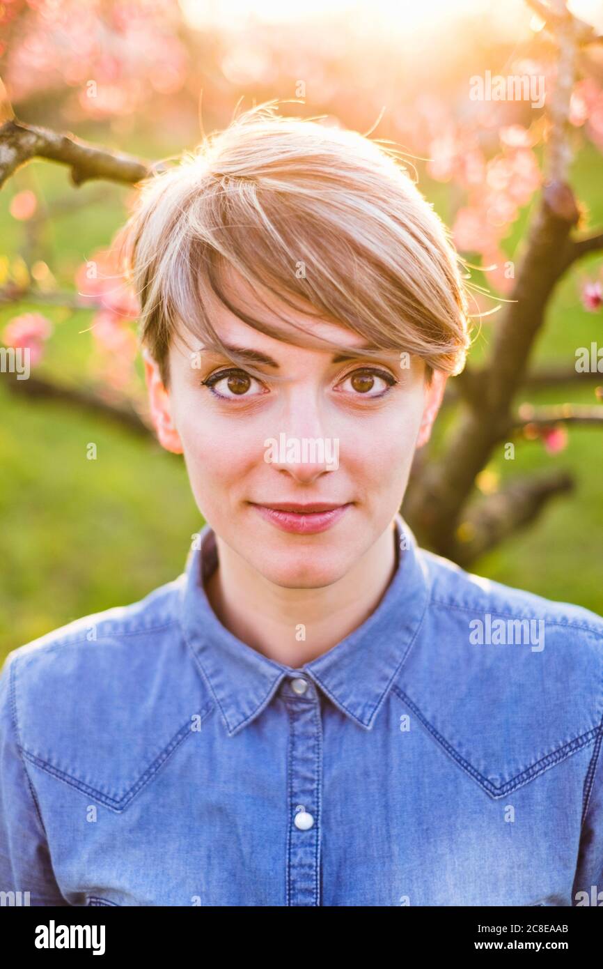 Nahaufnahme der schönen Frau mit kurzen Haaren im Park während Frühling bei Sonnenuntergang Stockfoto