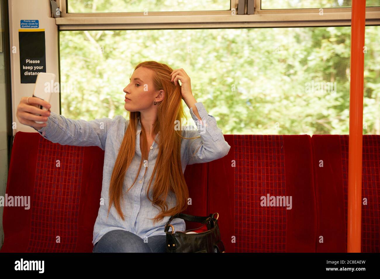 Schöne Frau, die Selfie beim Sitzen im Zug Stockfoto