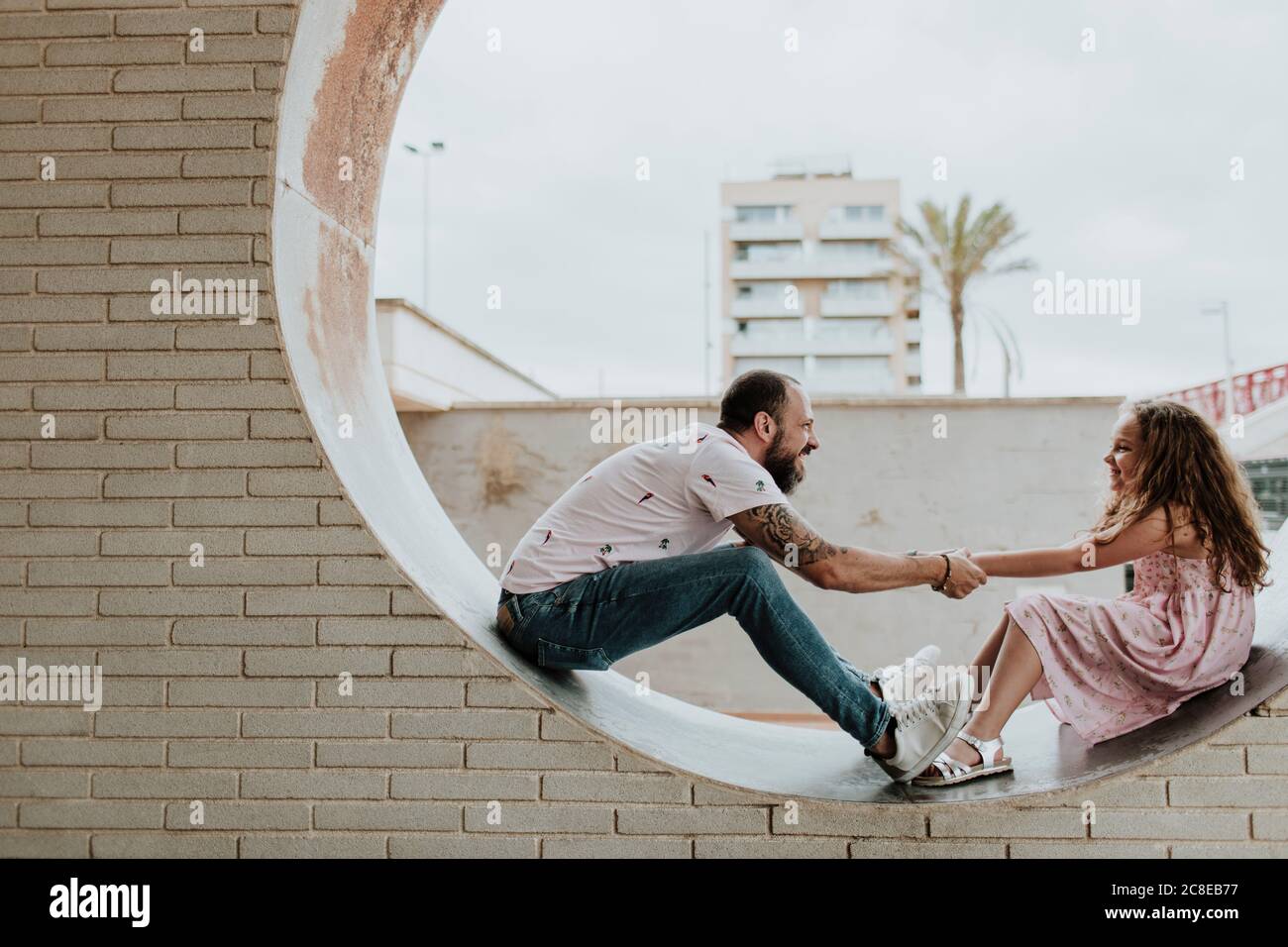 Vater und Tochter spielen im runden Fenster in der Wand Stockfoto