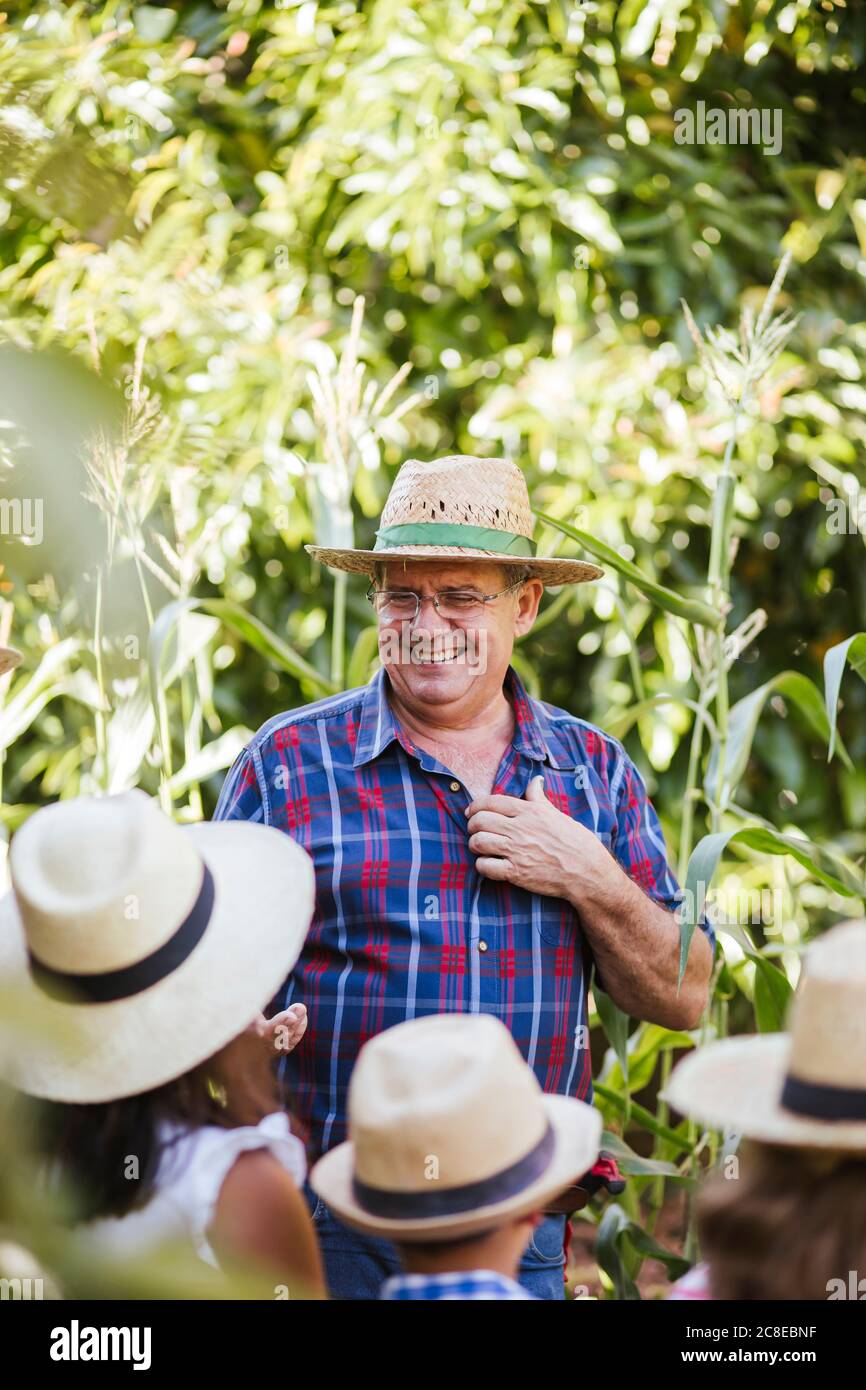 Grandfahter mit Gruppe von Kindern im Garten Stockfoto
