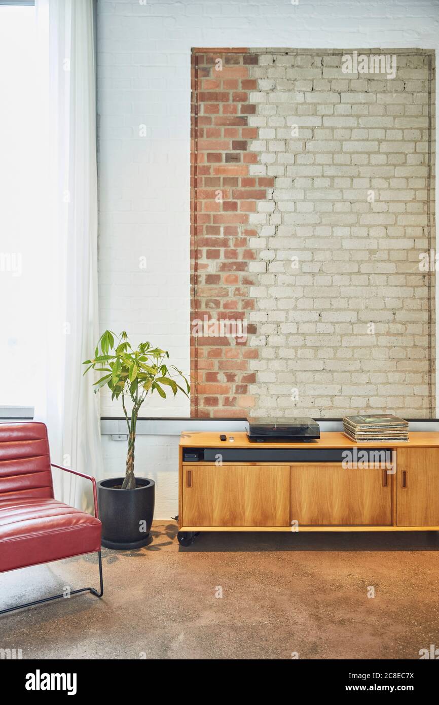 Innenraum einer Loft-Wohnung mit Backsteinwand und Brust Der Schubladen Stockfoto