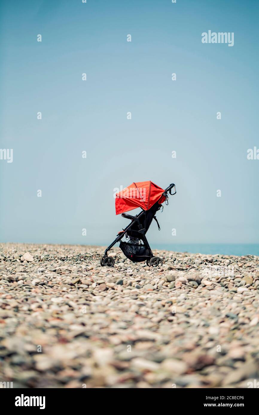 Georgia, Adjara, Batumi, Baby Kinderwagen links auf felsigen Küstenstrand im Sommer Stockfoto