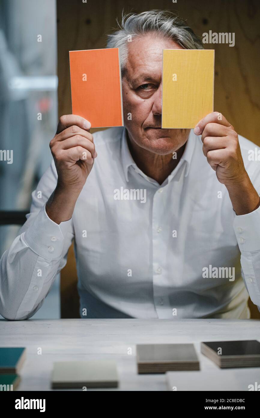 Architekt sitzt im Büro mit Farbmustern vor Sein Gesicht Stockfoto