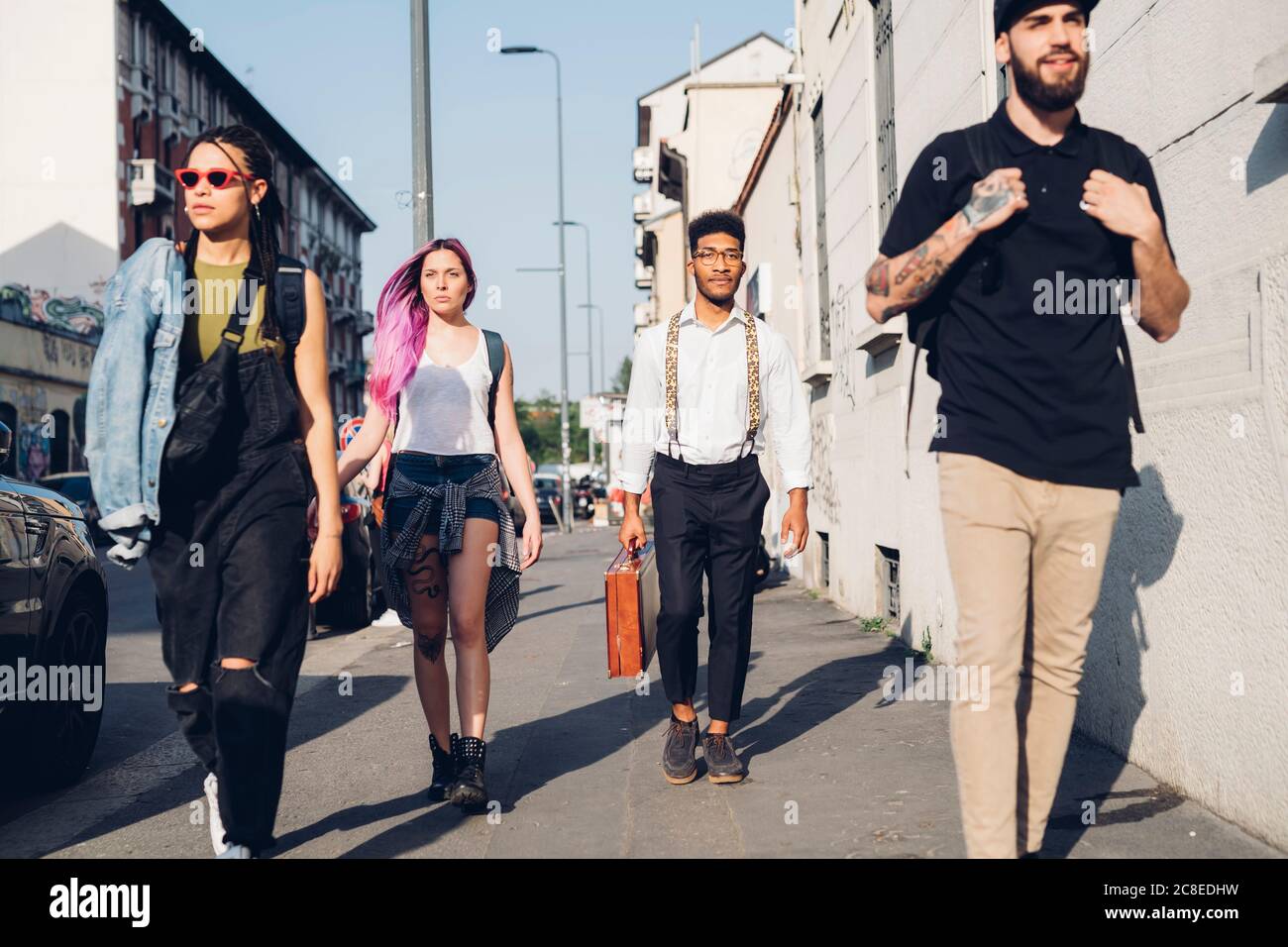 Eine Gruppe von Freunden, die auf dem Bürgersteig in der Stadt spazieren Stockfoto