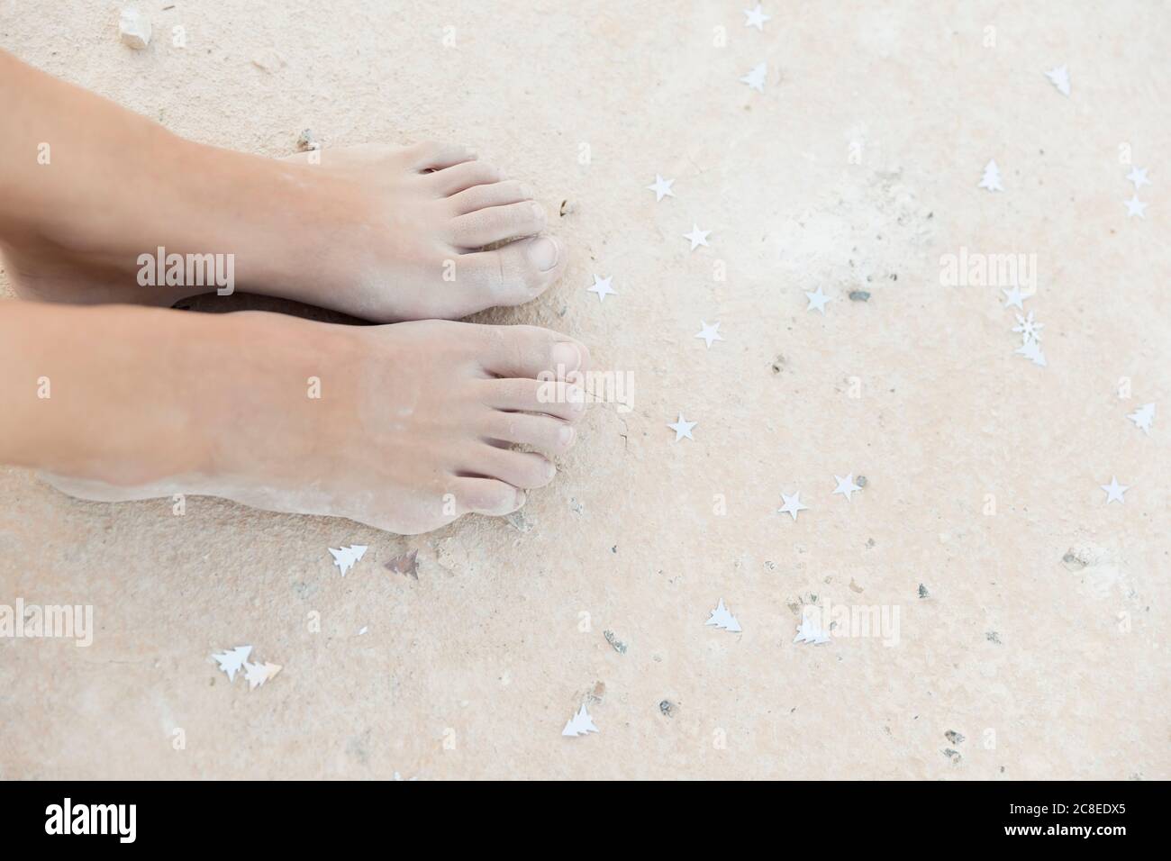 Zugeschnittenes Bild von weiblichen Füßen auf Sand Stockfoto