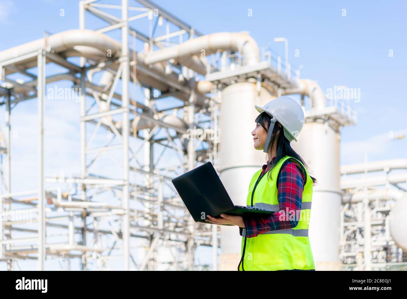 Asiatische Frau petrochemische Ingenieur arbeiten in der Nacht mit Laptop in Öl-und Gas-Raffinerie-Fabrik in der Industrie in der Nacht für Inspektor Sicherheit quali Stockfoto