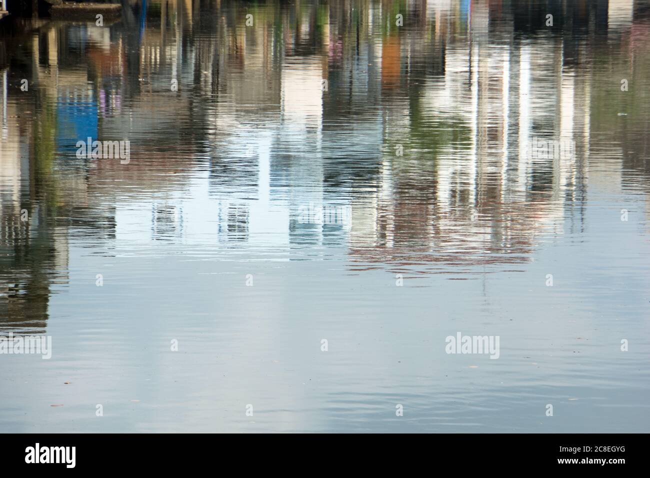 Abstrakte Gebäude, die sich im Wasser mit gewellten Hintergrundfarben spiegeln, aus Thailand. Stockfoto