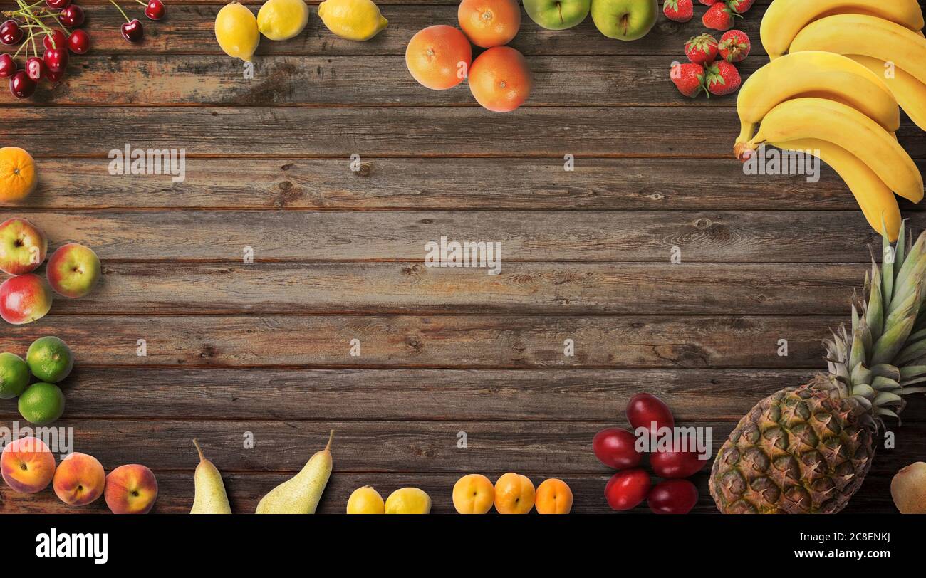 Früchte Hintergrund. Food Fotografie verschiedene Arten von Früchten auf einem hölzernen Hintergrund. Speicherplatz kopieren. Produkt mit hoher Auflösung isoliert. Farbenfrohe Kulisse Stockfoto