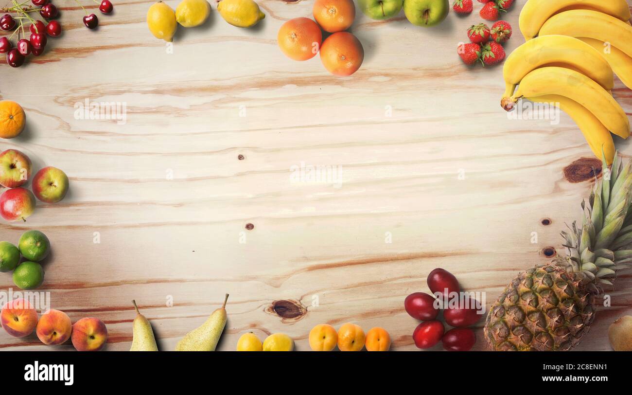 Früchte Hintergrund. Food Fotografie verschiedene Arten von Früchten auf einem hölzernen Hintergrund. Speicherplatz kopieren. Produkt mit hoher Auflösung isoliert. Farbenfrohe Kulisse Stockfoto