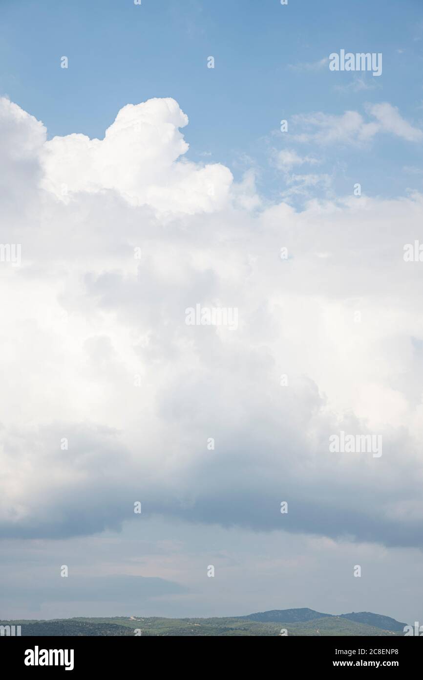 Weiße Wolken am blauen Himmel und Hügel an einem Sommertag Stockfoto