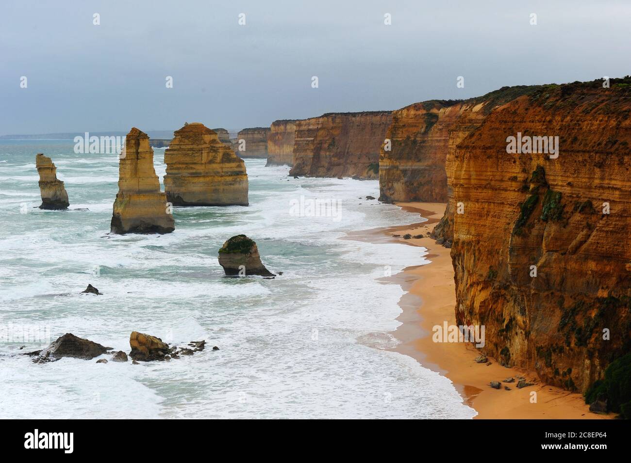 Die malerische Felsformation Twelve Apostles entlang der steilen Klippenküste der Great Ocean Road in Victoria, Australien, mit bewölktem Himmel und wildem Meer. Stockfoto