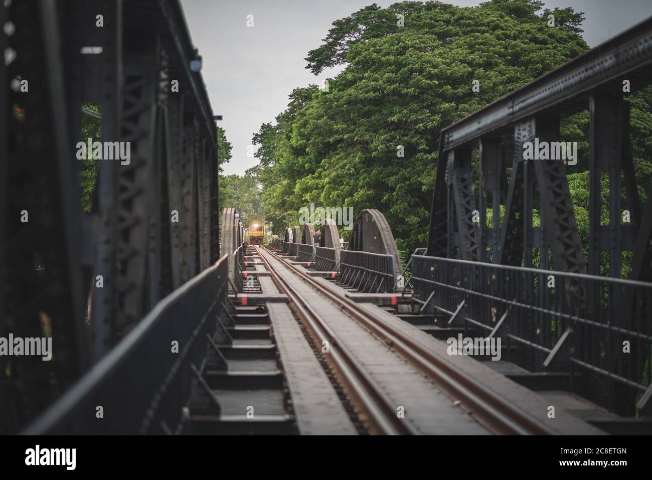 Die Landschaft des Zuges kommt auf der Eisenbahnbrücke über den Kwai Fluss in der Provinz Kanchanaburi, Thailand. Stockfoto