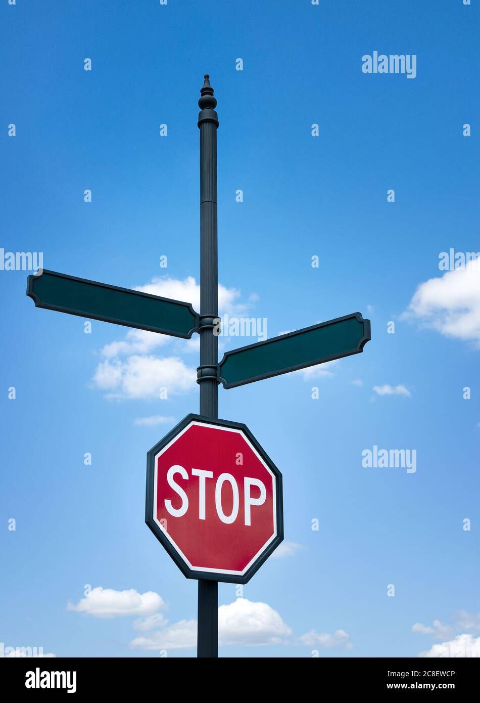 Ein Stoppschild und leere Straßenschilder gegen blauen Himmel und weiße Wolken. Platz für Ihren benutzerdefinierten Text. Konzept für die Entscheidungsfindung, zwei Alternativen. Stockfoto