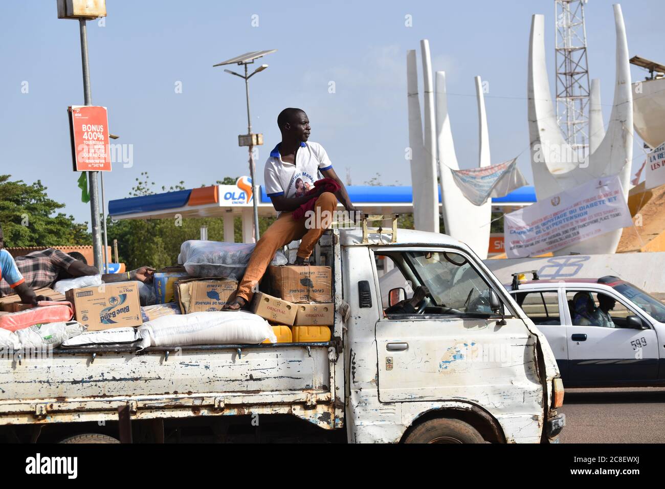 Ein Arbeiter, der auf der Last eines Lieferwagens in Niamey, Niger, sitzt. Stockfoto