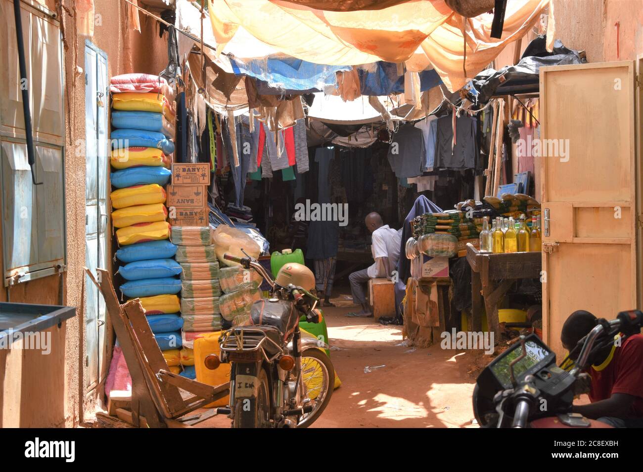 Hängende Planen bieten Schatten zu einem überfüllten Gang in einem afrikanischen Markt Stockfoto