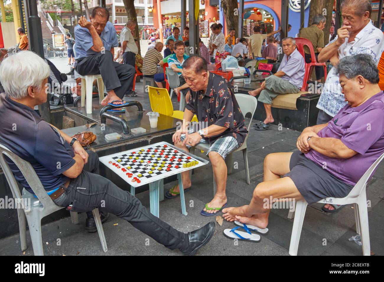 Ältere oder pensionierte ethnische Chinesen auf dem Kreta Ayer Square, Chinatown, Singapur, vertieft oder teilweise schlafend während einer Partie chinesischem Schach Stockfoto