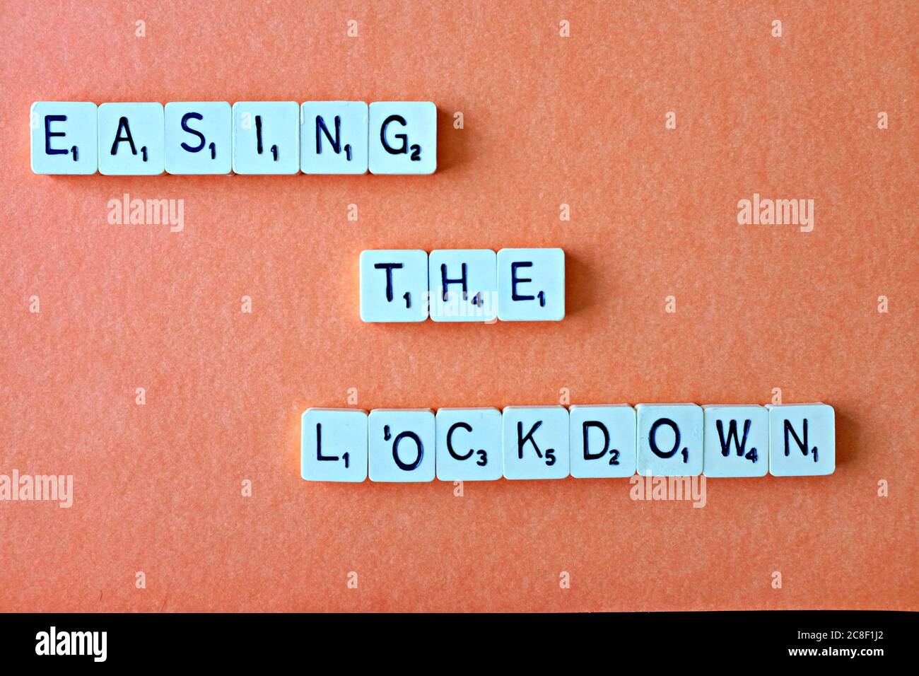 Die Wörter - Lockdown - buchstabiert heraus in quadratischen Buchstaben auf einem bernsteinfarbenen Hintergrund, mit reichlich redaktionellen/copy Raum Stockfoto