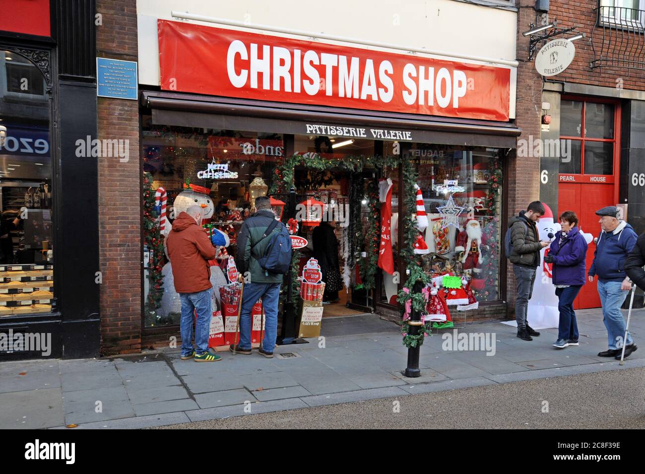 Einkäufer, die in einem Pop-up-weihnachtsgeschäft in einem ehemaligen Patisserie Valerie Bäckerei-Geschäft stöbern Stockfoto