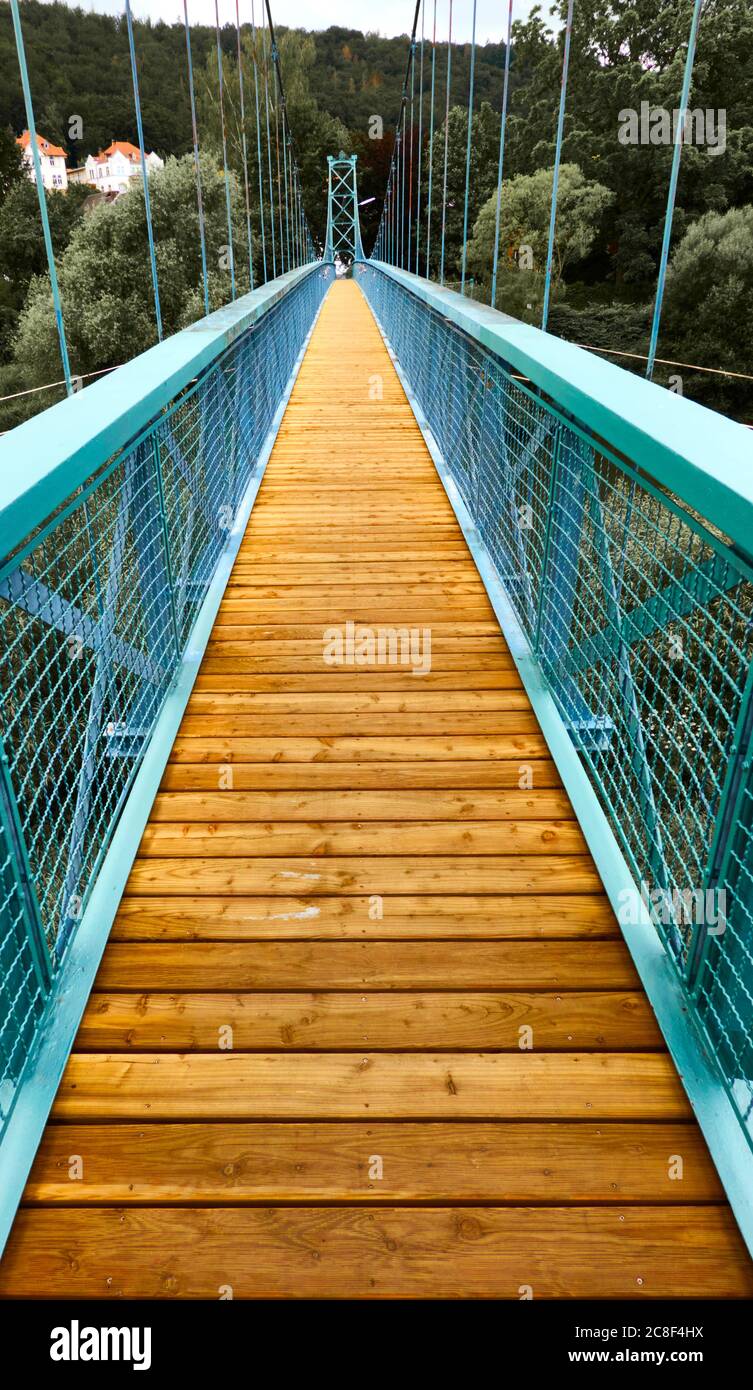 Zentrale Perspektive einer Eisenbrücke für Fußgänger mit Holzboden Stockfoto
