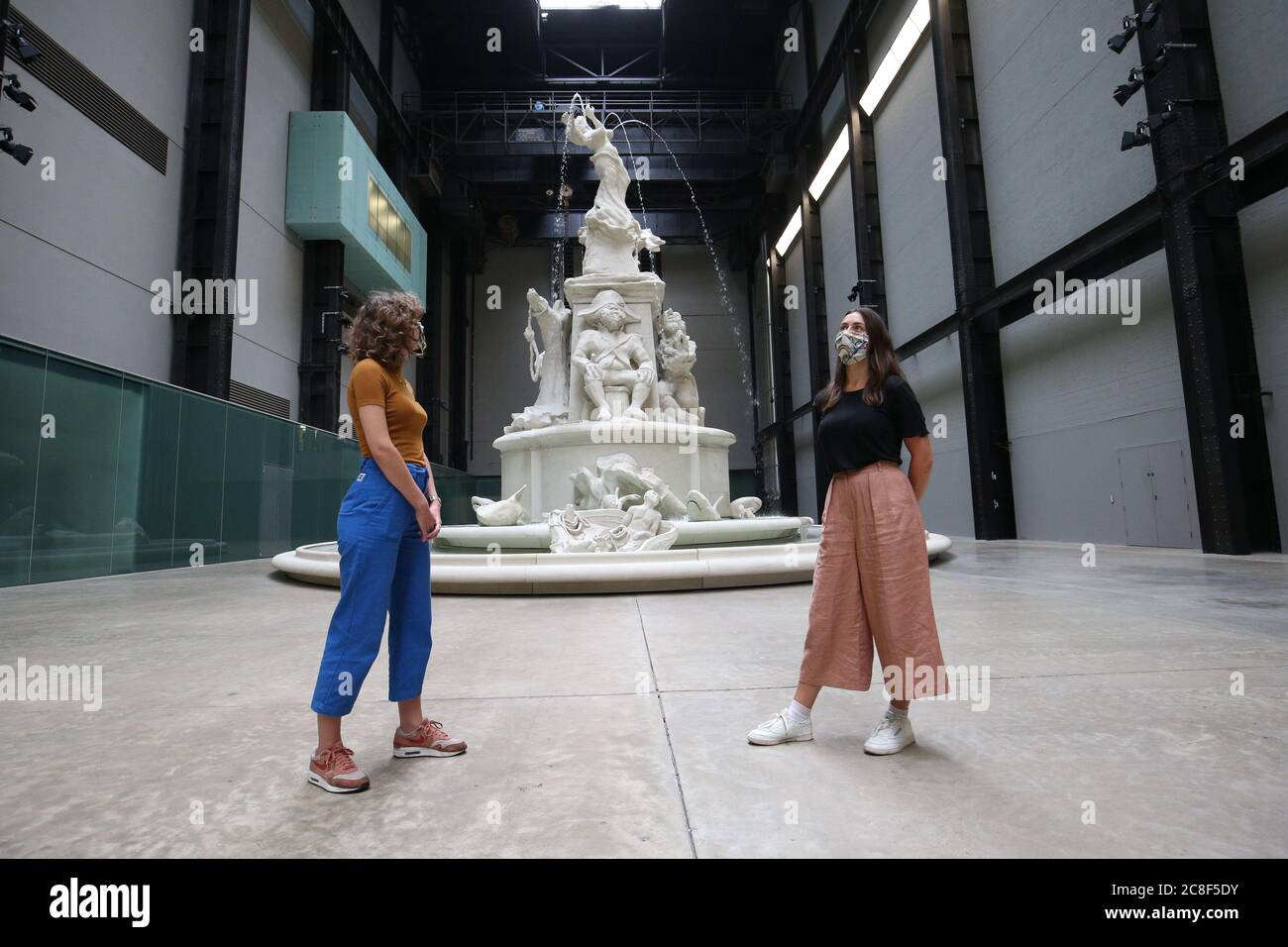 Mitarbeiter posieren vor Kara Walkers Installation 'Fons Americanus' in der Turbine Hall der Tate Modern, während sich die Galerie nach der Sperrung des Coronavirus am Montag, 27. Juli, für die Öffentlichkeit öffnet. Stockfoto