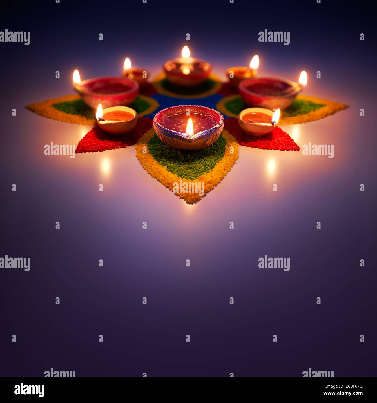 Happy Diwali, glühende Öllampen auf bunten Rrangoli Stockfoto
