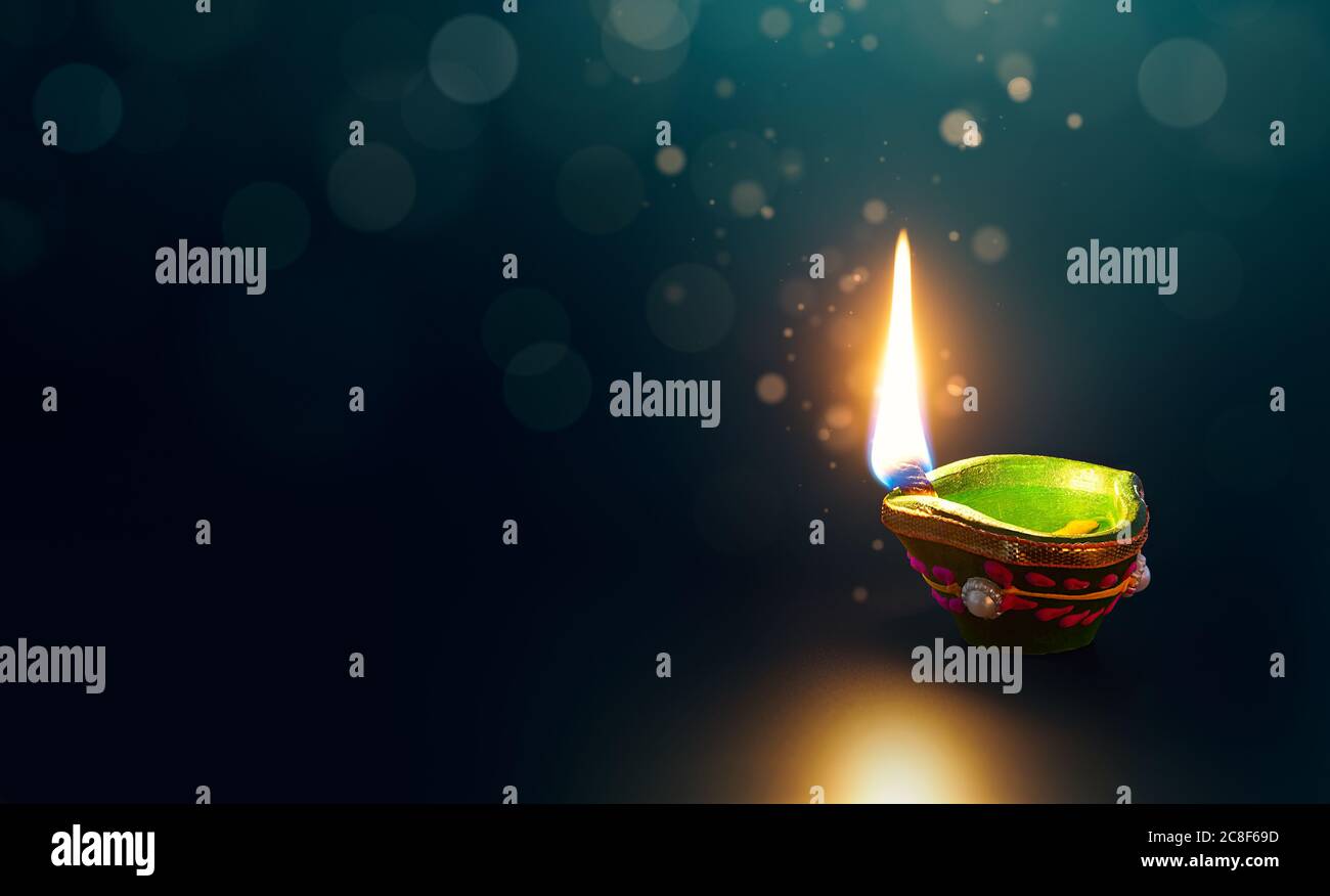 Happy Diwali, glitzernde Diya Öllampe auf dunklem Hintergrund mit Kopierraum Stockfoto