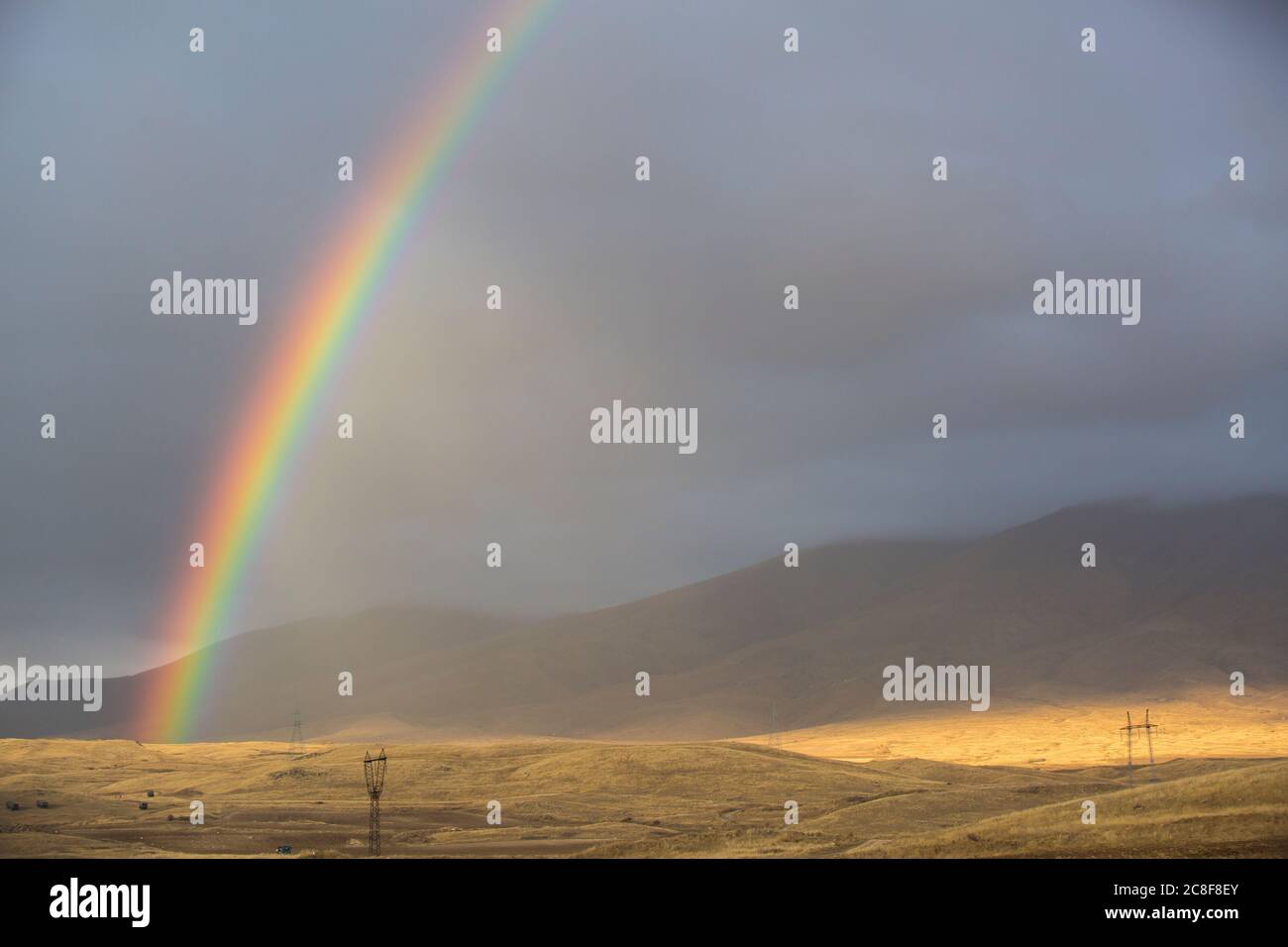 Ein doppelter Regenbogen zieht sich durch die Landschaft auf der Straße von Goris nach Shaki in der südwestlichen Ecke Armeniens. Stockfoto