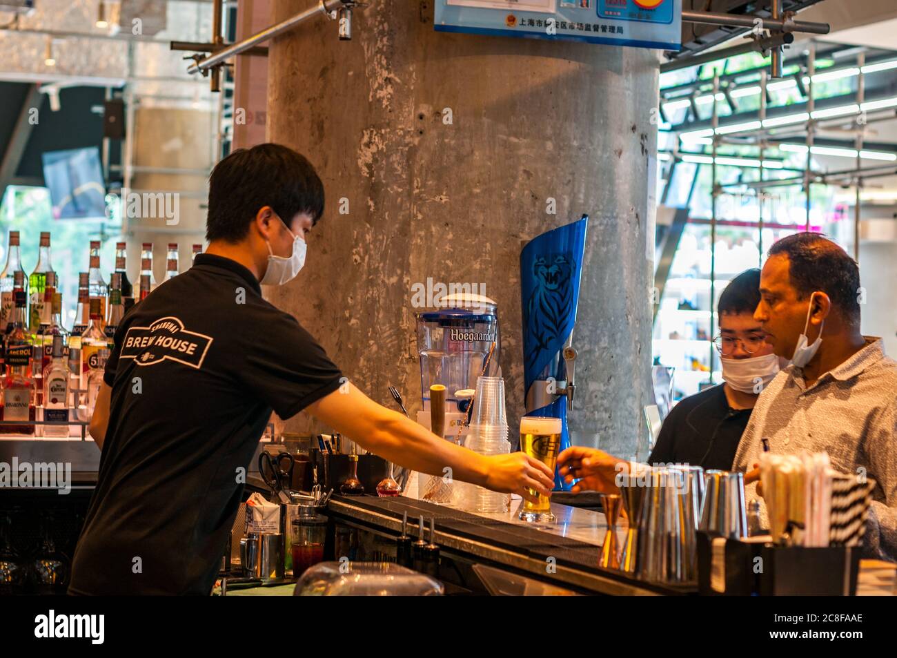 Übergabe eines Bieres im Shanghai Brewhouse im Jing’an District. Stockfoto
