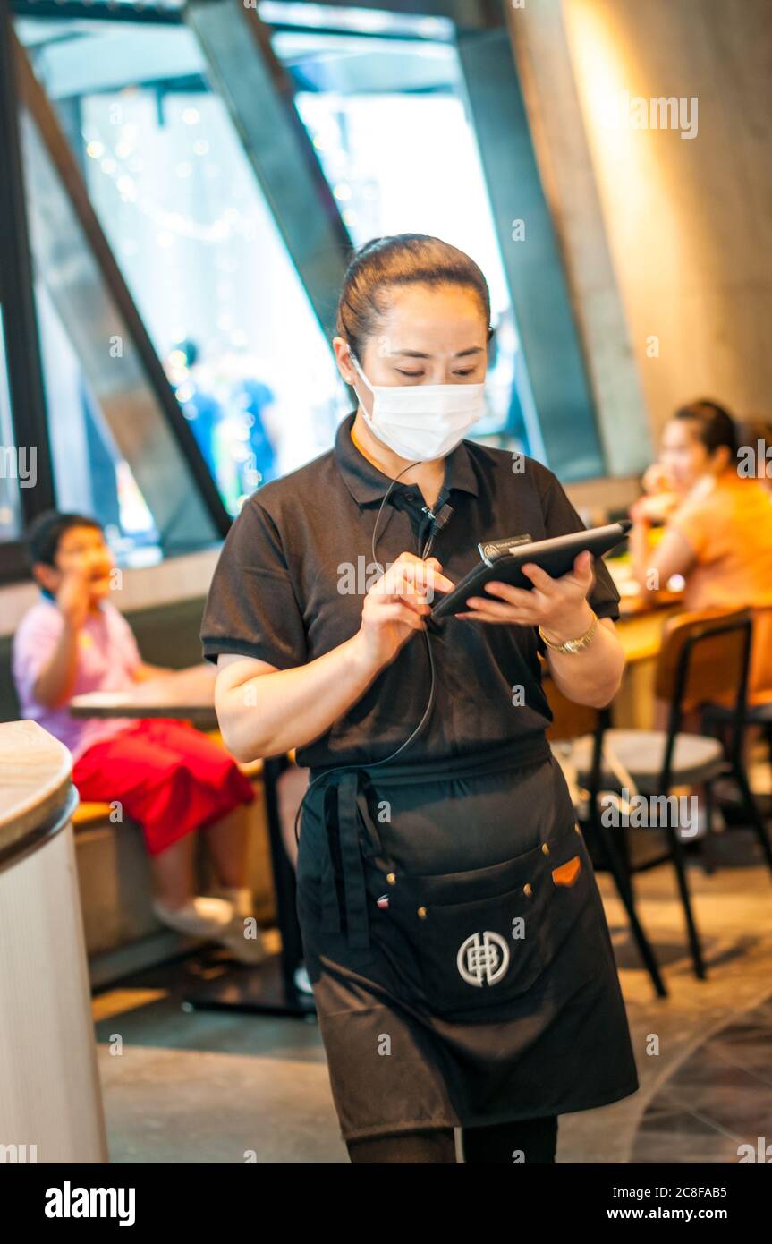 Eine Kellnerin bei Shanghai Brewhouse im Jing’an District mit dem Tablet-basierten Bestellsystem. Stockfoto