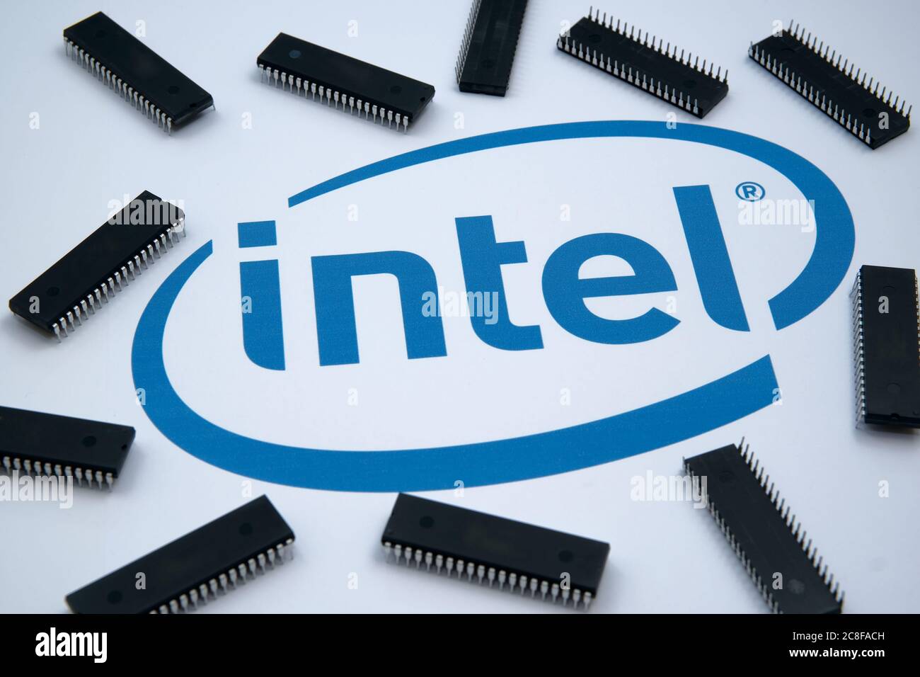 Intel Firmenlogo auf dem Papier und Mikrochips, die herum platziert sind. Selektiver Fokus. Stockfoto
