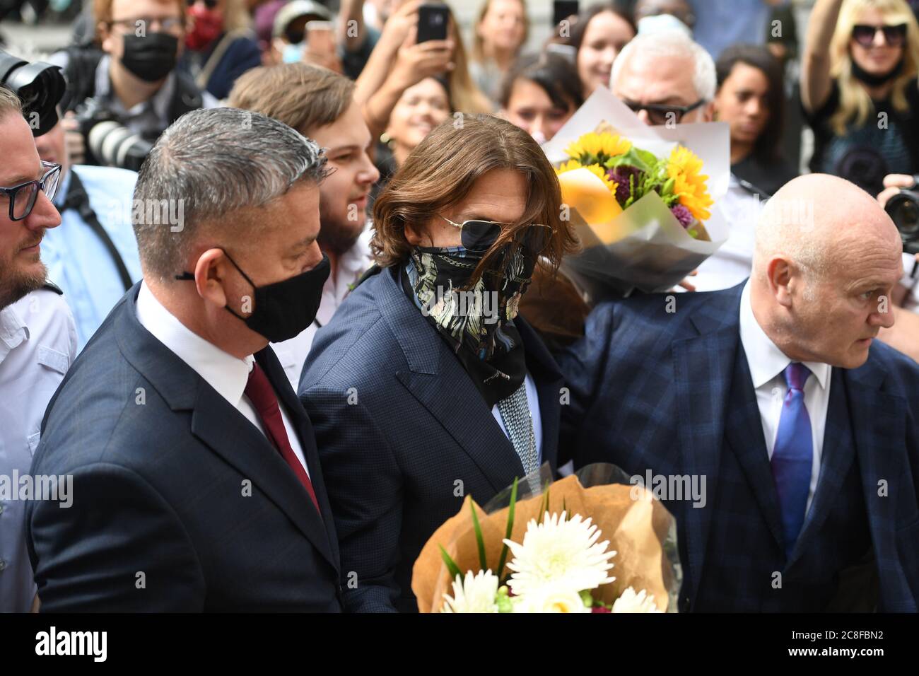 Schauspieler Johnny Depp erhält Blumen, als er am High Court in London für eine Anhörung in seinem Verleumdungsverfahren gegen die Herausgeber von The Sun und dessen Chefredakteur Dan Wootton ankommt. Stockfoto