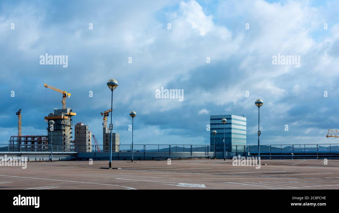 Leeres Parkdeck mit Bürogebäude und Baustelle im Hintergrund. Stockfoto