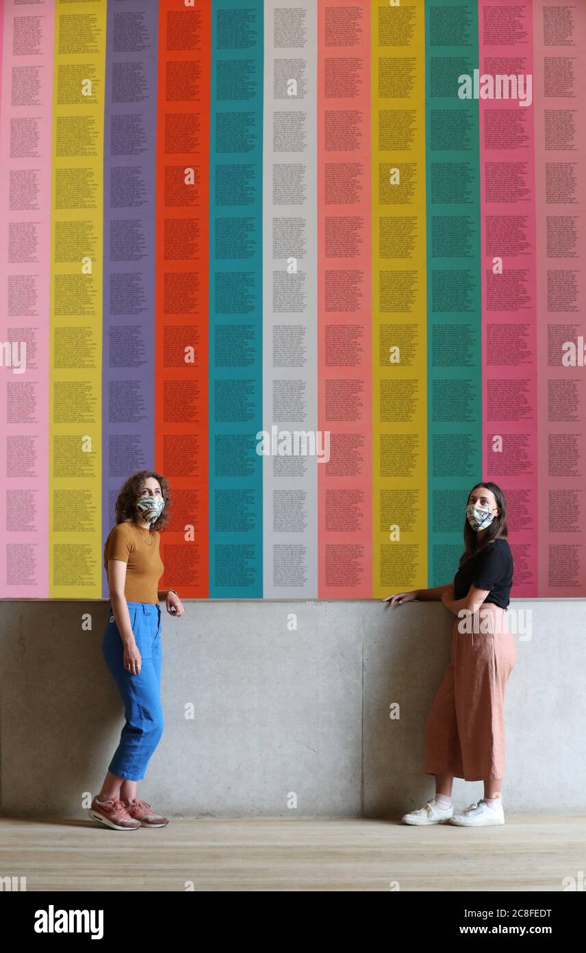 Mitarbeiter tragen kunstkunstkunstvolle Masken, während sie vor Jenny Holzers "inflammatory Essays" in der Tate Modern stehen, während sich die Galerie nach der Sperrung des Coronavirus am Montag, dem 27. Juli, für die Öffentlichkeit öffnet. Stockfoto