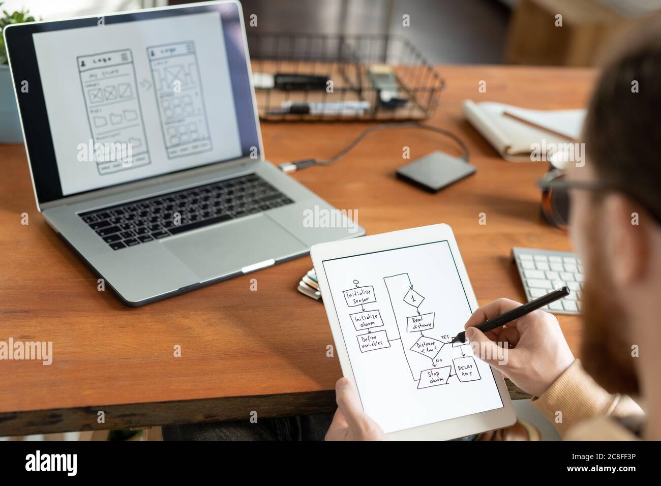 Über die Schulter Ansicht des Menschen mit digitalen Tablet und Stift und Zeichnung Schema für ui-Design Stockfoto