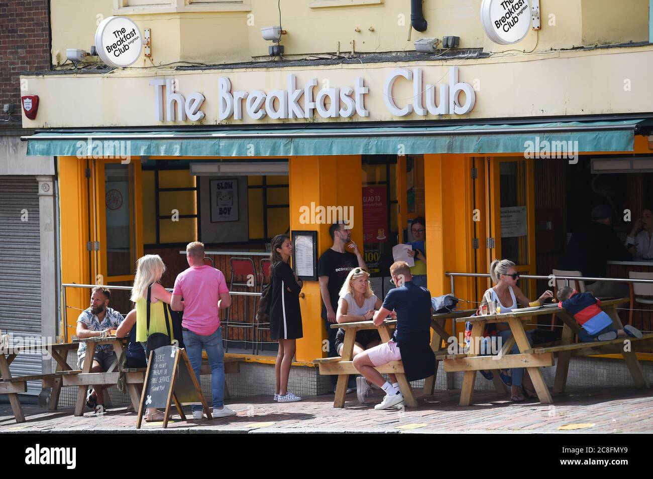 Brighton UK 24. Juli 2020 - Besucher genießen das Essen im Restaurant des Breakfast Club an einem heißen Tag in Brighton mit Temperaturen, die in einigen Teilen des Südostens heute 25 Grad erreichen werden : Credit Simon Dack / Alamy Live News Stockfoto