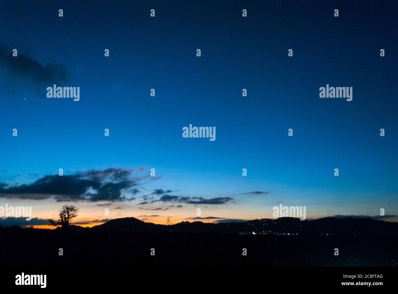 Dramatische Sonnenuntergang in Guatemala, Dezember, Sonnenuntergang und Berge Silhouetten, trockene Baum Silhouette. Stockfoto