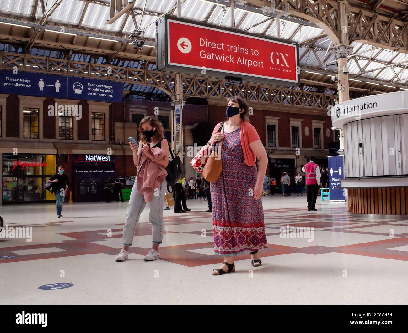 London Victoria Station - Zug Passagiere mit Covid 19 Masken Stockfoto
