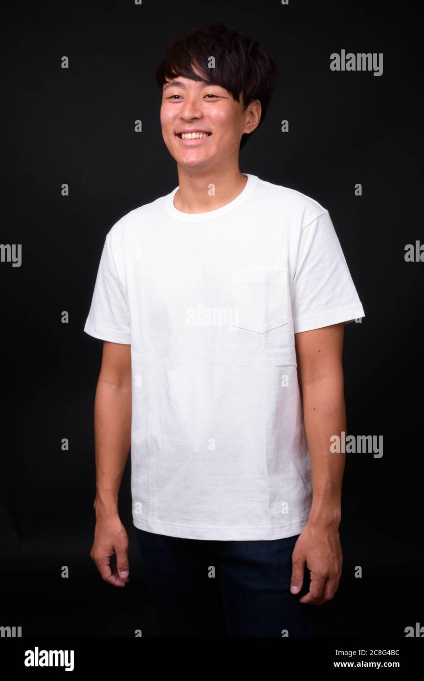 Die Jungen gut aussehenden asiatischer Mann auf schwarzem Hintergrund Stockfoto