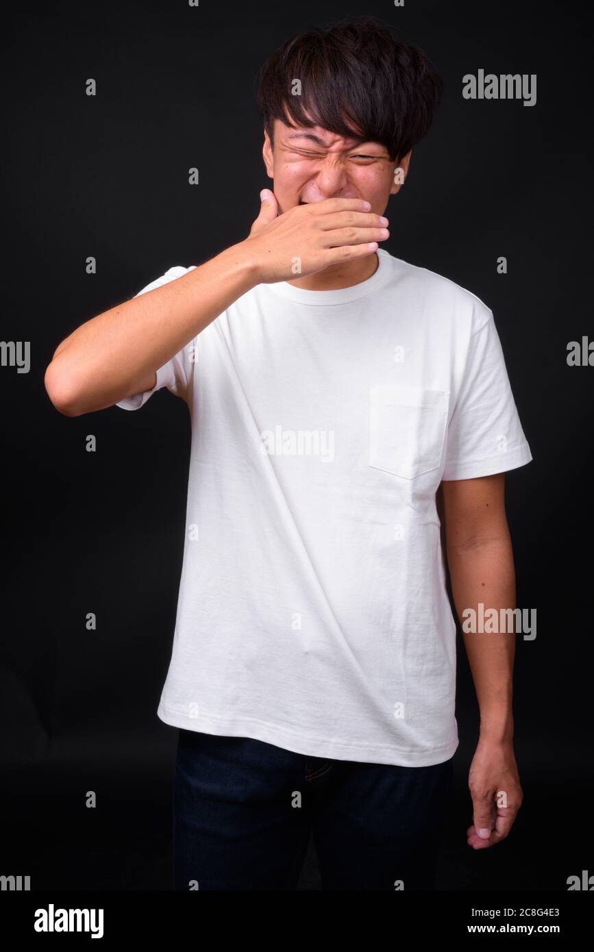 Die Jungen gut aussehenden asiatischer Mann auf schwarzem Hintergrund Stockfoto