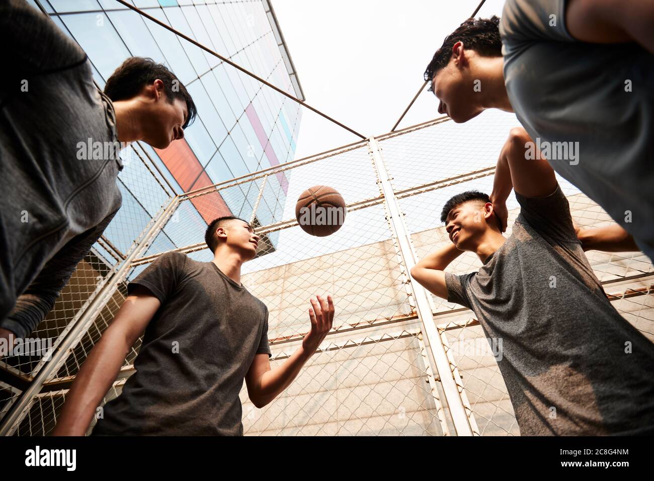 Junge asiatische Erwachsene Männer mit Spaß spielen mit Basketball im Freien Stockfoto