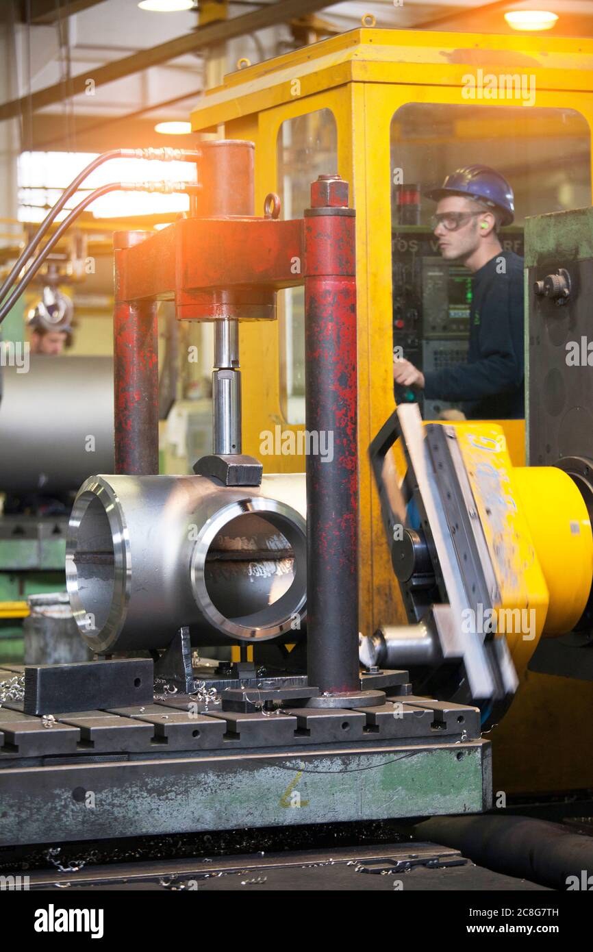 Mann, der an einer Maschine in einer Stahlfabrik arbeitet. Stockfoto