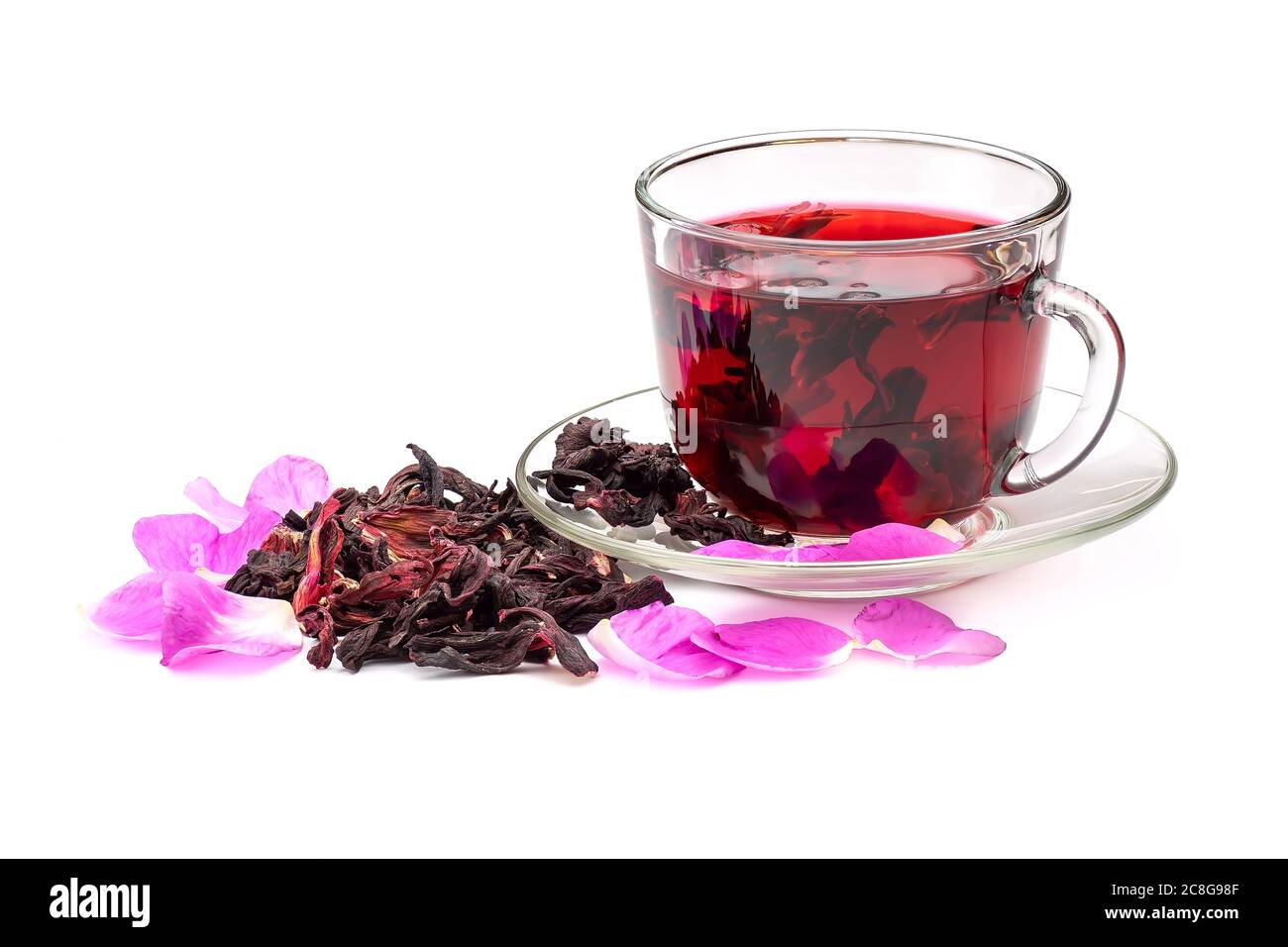 Hibiscus Tee in Glas Tasse zwischen den Rosenblättern und trockenen Blütenblättern isoliert auf weißem Hintergrund. Stockfoto