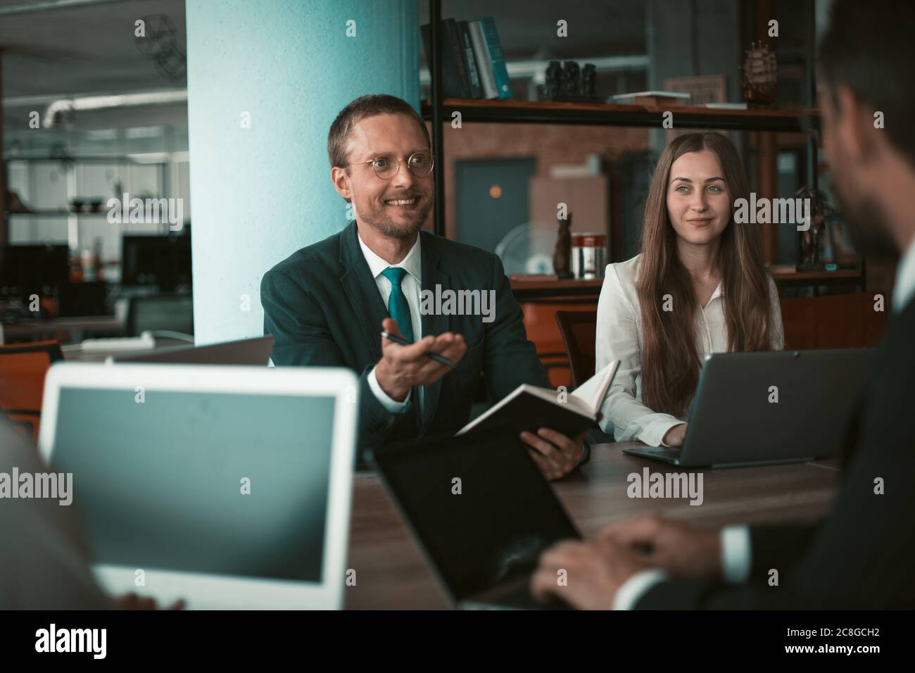 Geschäftsleute Brainstorming zusammen im Büro. Selektiver Fokus auf lächelnde Frau mit Laptop. Teamarbeit über Entwicklungsstrategie für Startup-Projekt Stockfoto