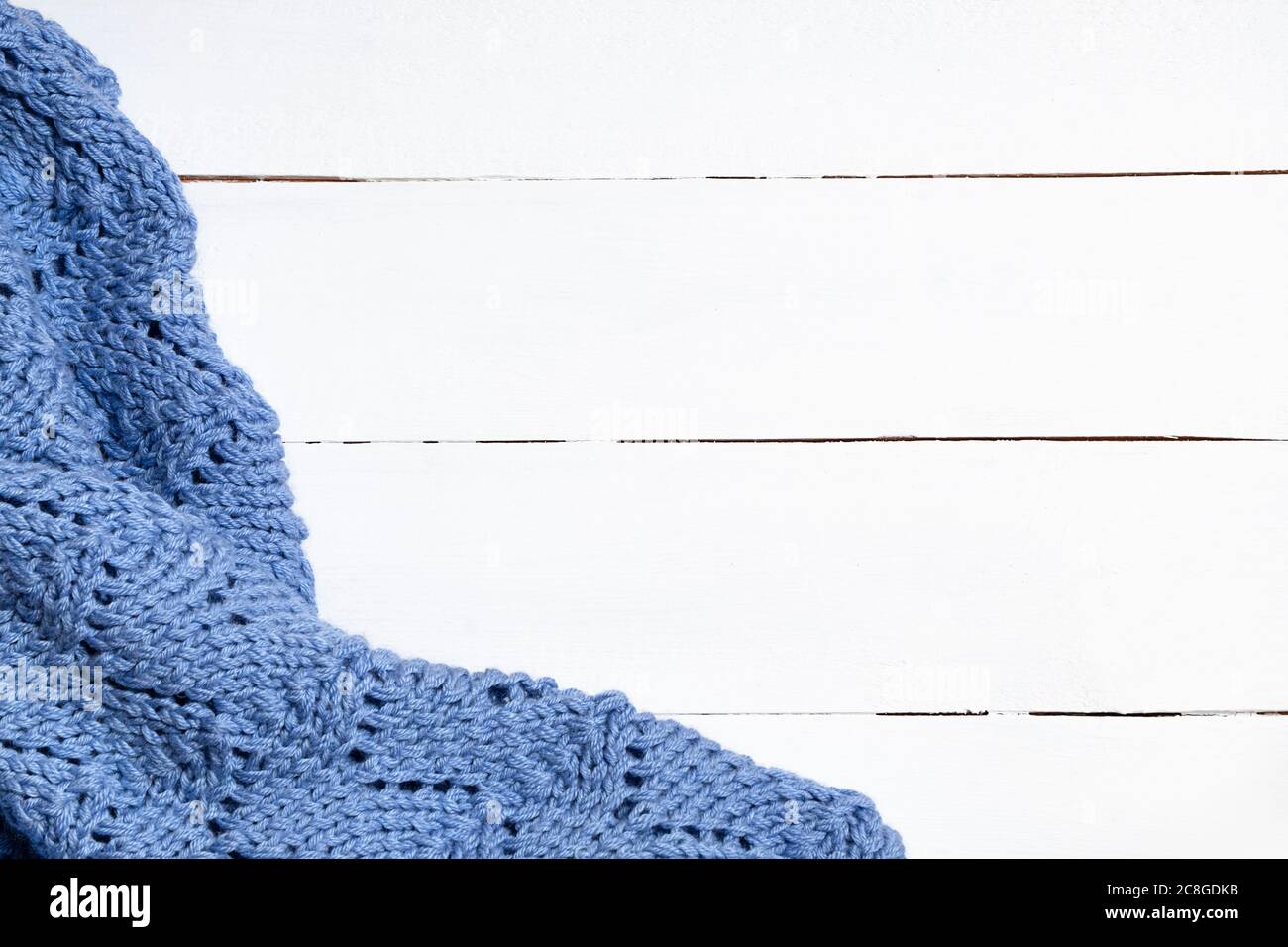 Gestrickte Wolldecke auf weißem Holzhintergrund. Weihnachten festliche Hintergrund für den Winter Stockfoto