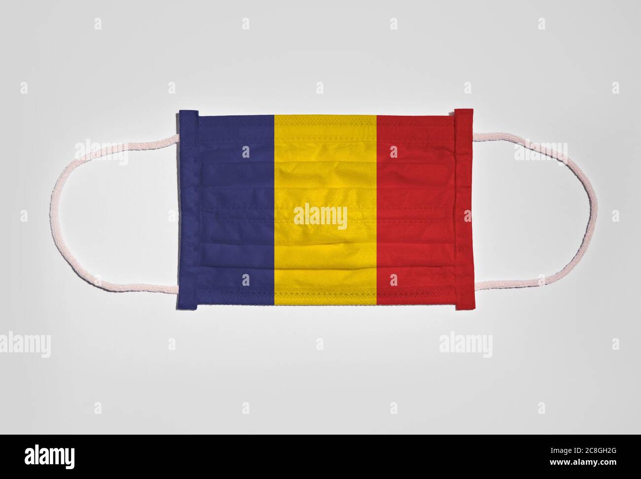Symbolbild Corona Krise, Mundschutz, Atemmaske, Mund- und Nasenschutz mit Flagge Rumäniens, weißer Hintergrund Stockfoto