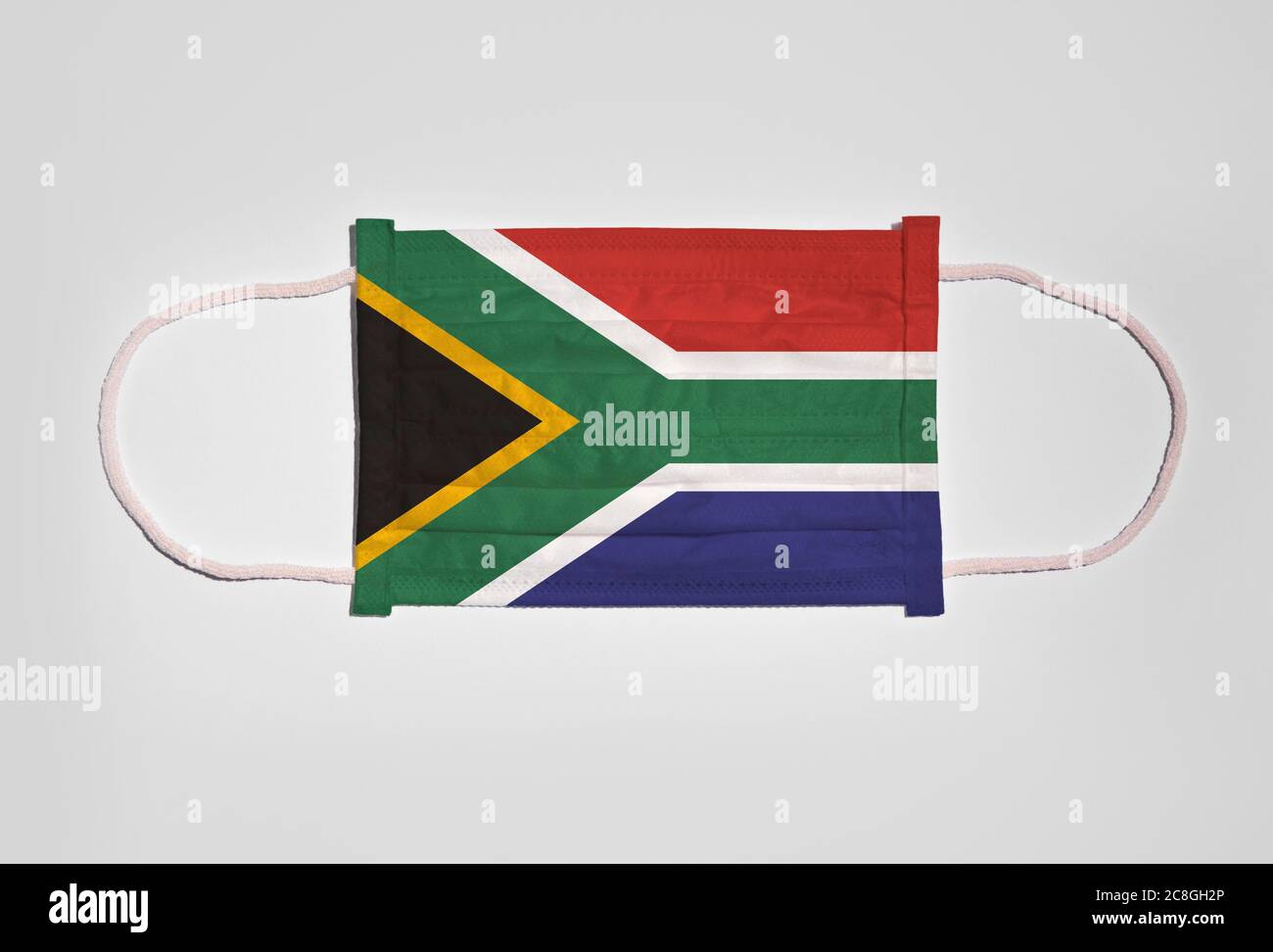 Symbolbild Corona Krise, Mundschutz, Atemmaske, Mund- und Nasenschutz mit Flagge Südafrikas, weißer Hintergrund Stockfoto