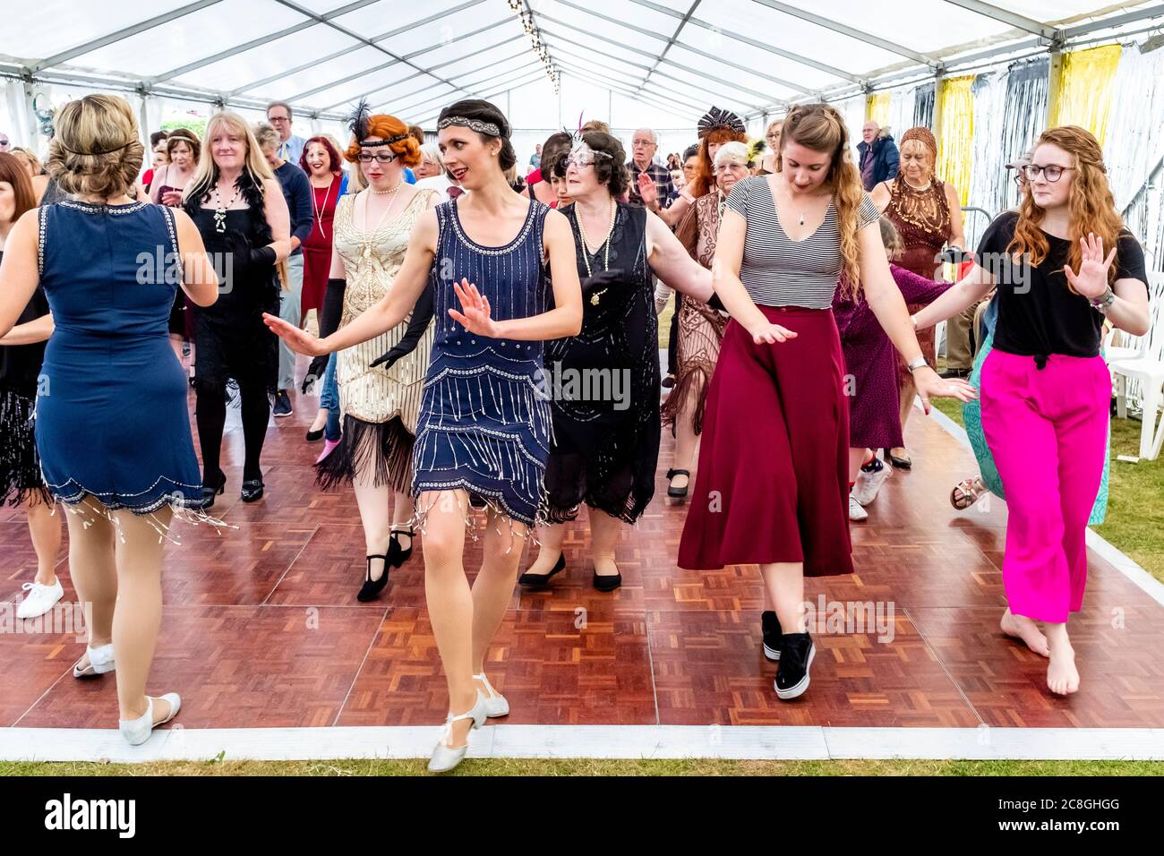 Frauen tanzen auf der Great Gatsby Fair, Bexhill on Sea, East Sussex, Großbritannien Stockfoto